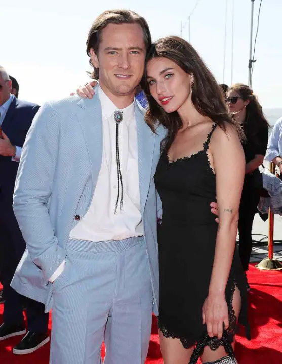 While not his wife, Lewis Pullman had a public relationship with Rainey Qualley. netflixdeed.com